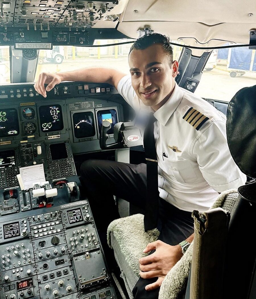 Neel Kamal Chopra, FAA Designated Pilot Examiner, seated at the flight deck controls in uniform.